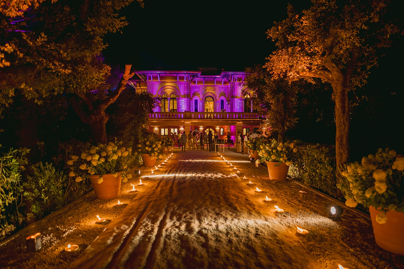 Villa Alpebella illuminated at night during an event in the park